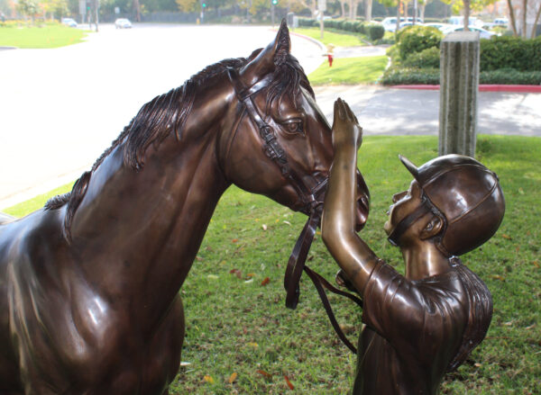 bronze statue of a girl and horse