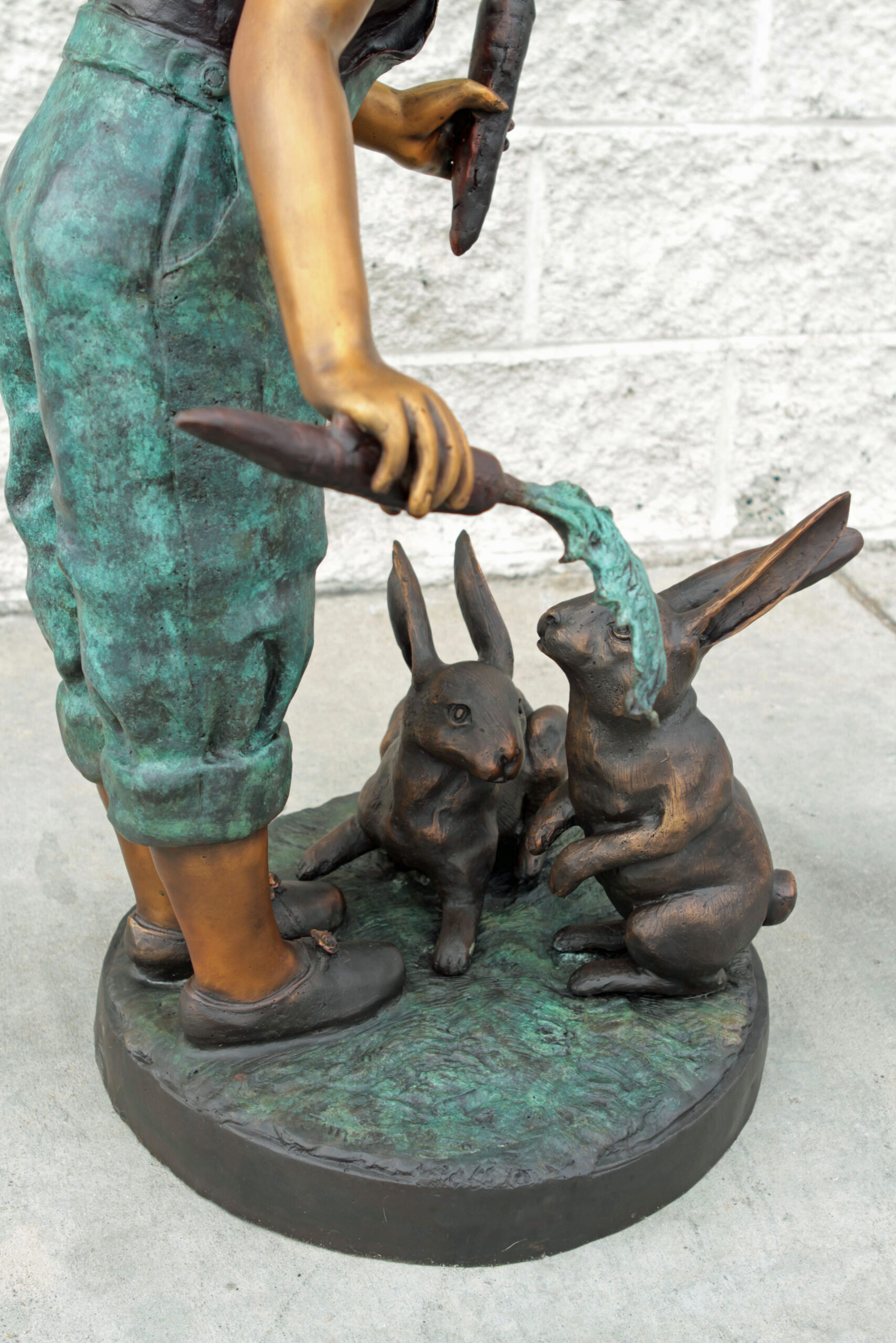 bronze statue of girl feeding rabbits