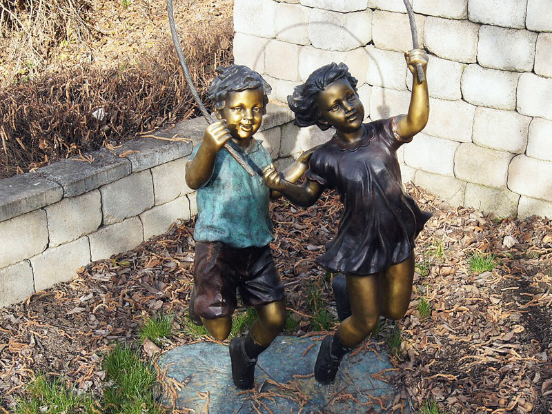 bronze statue of boy and girl playing jump rope