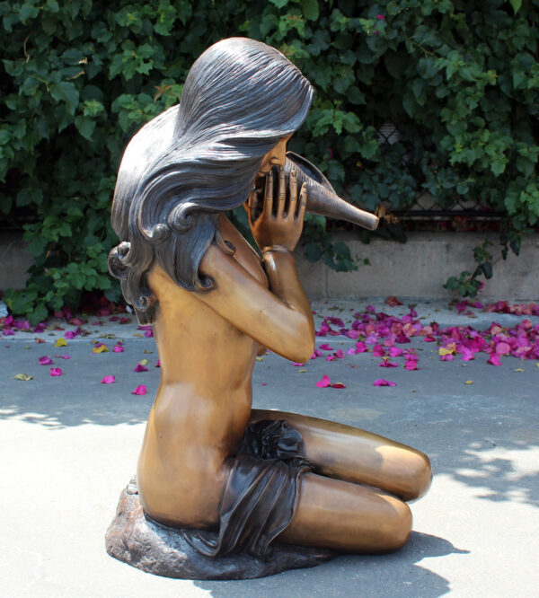 bronze statue of a girl holding a shell