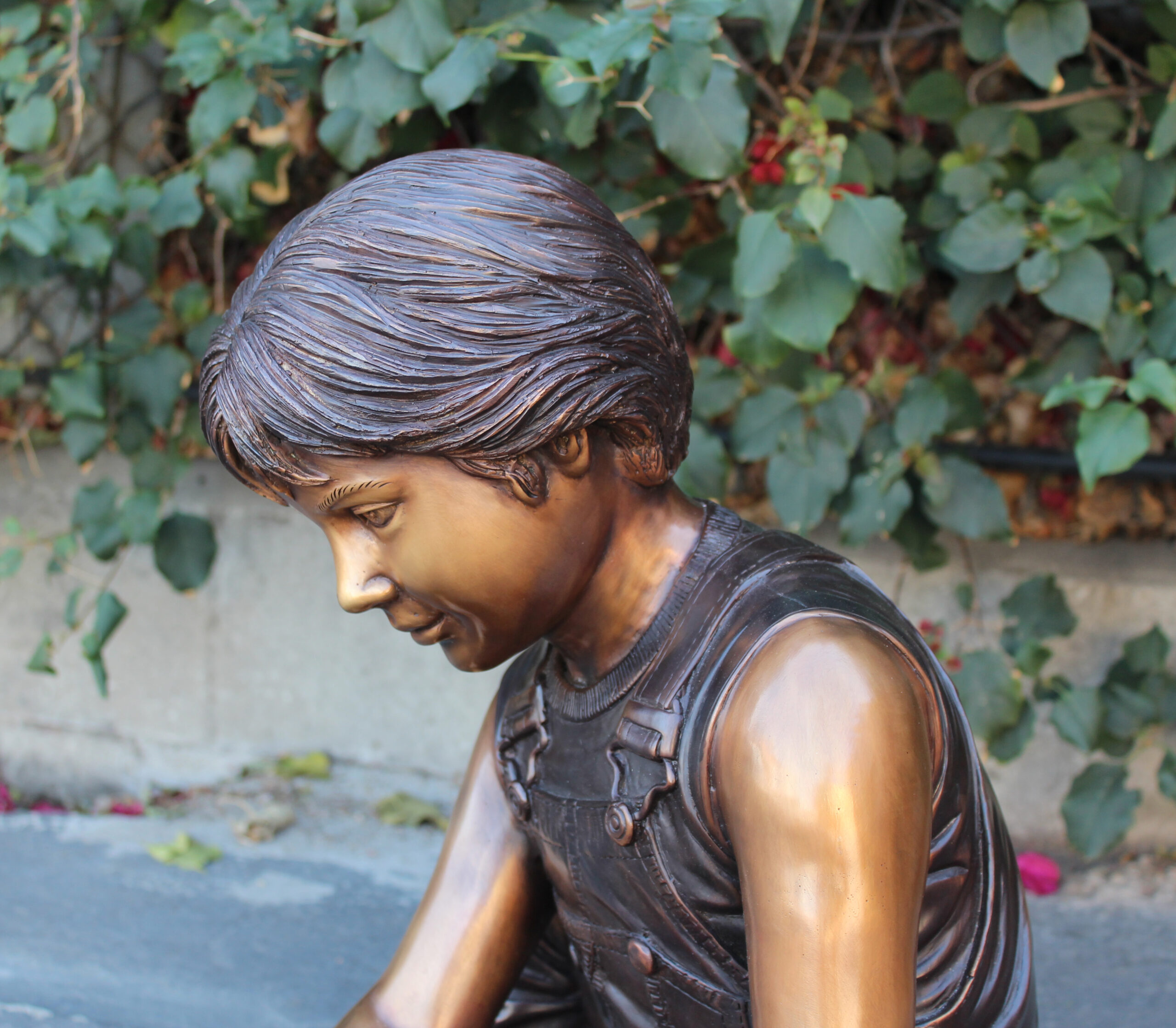 bronze statue of boy playing with turtle