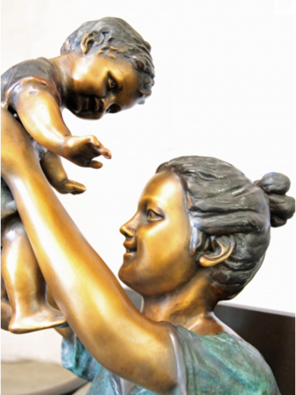 bronze statue of a mother and baby on bench