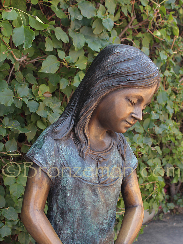 bronze statue of girl with watering can