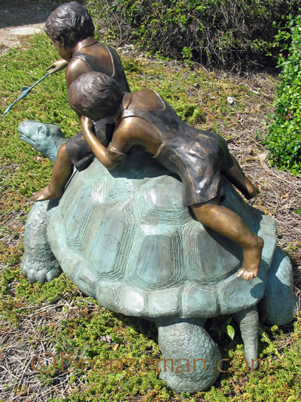 bronze statues of children on turtle