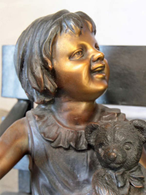 bronze statue of grandmother and girl on bench