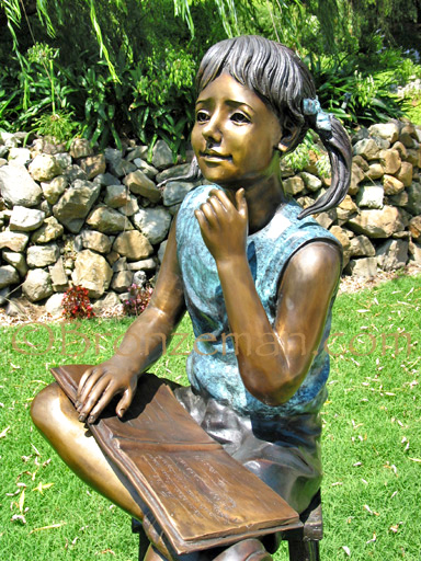 bronze statue of girl with book