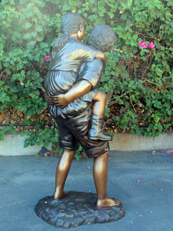bronze statue of children playing piggyback