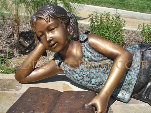 bronze statue of a girl reading