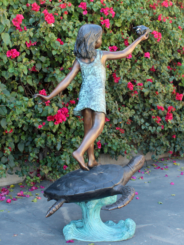 bronze statue of a girl standing on a turtle
