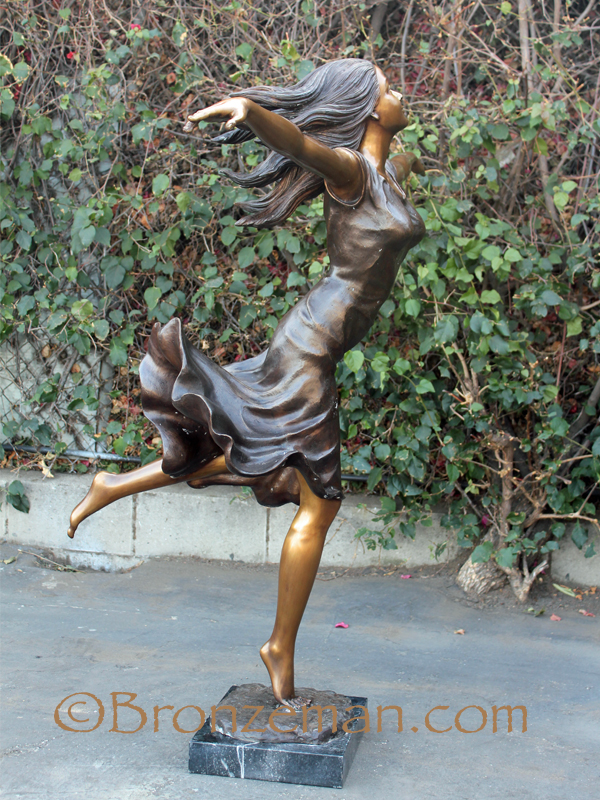 bronze statue of a woman with her arms out