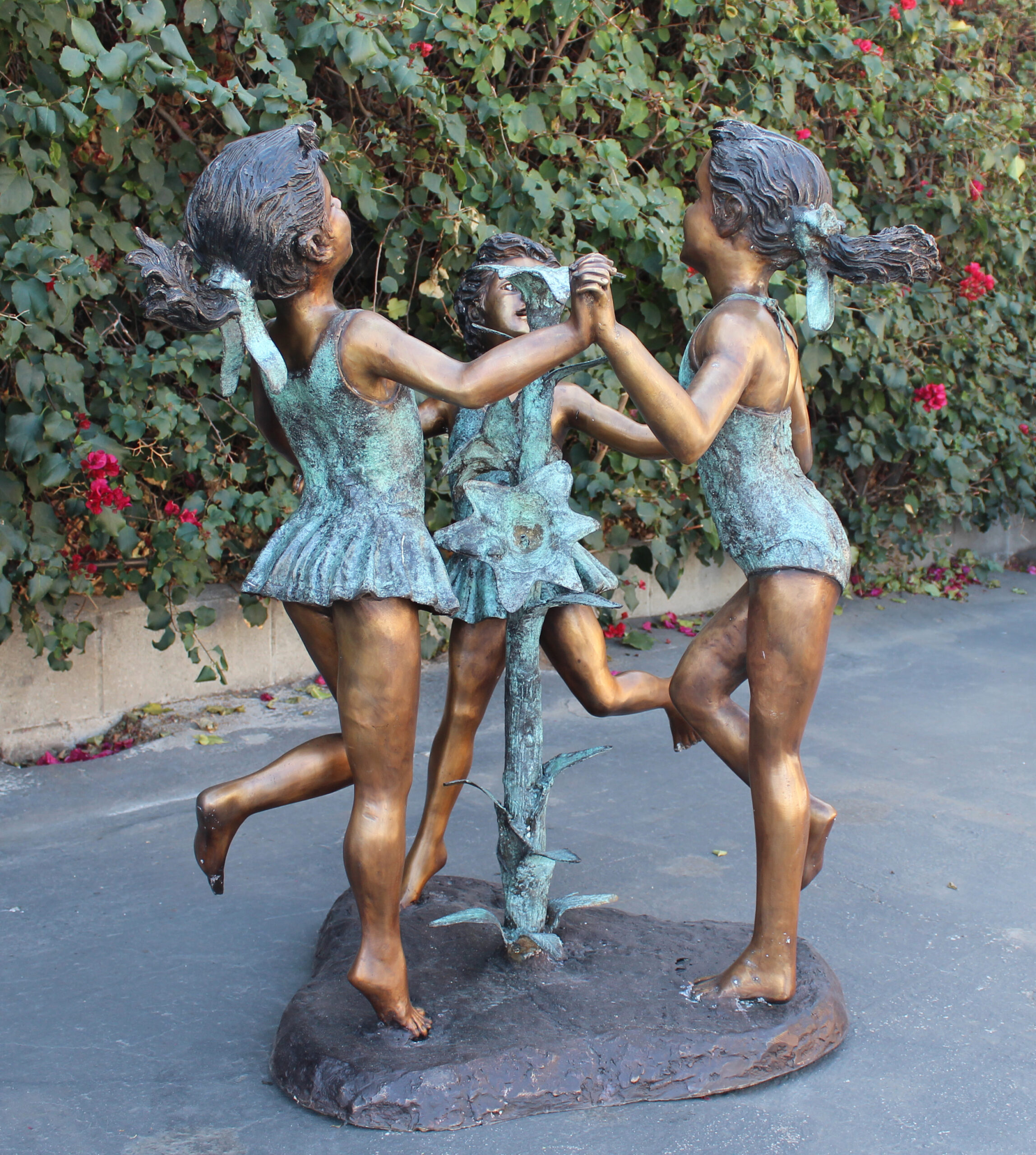 bronze statue of 3 girls dancing