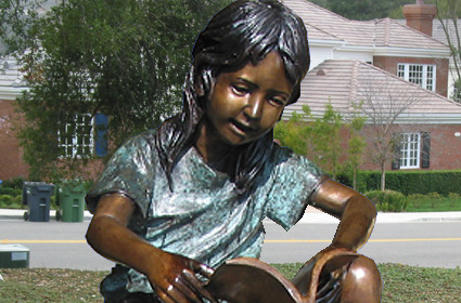 bronze statue of children reading on a log