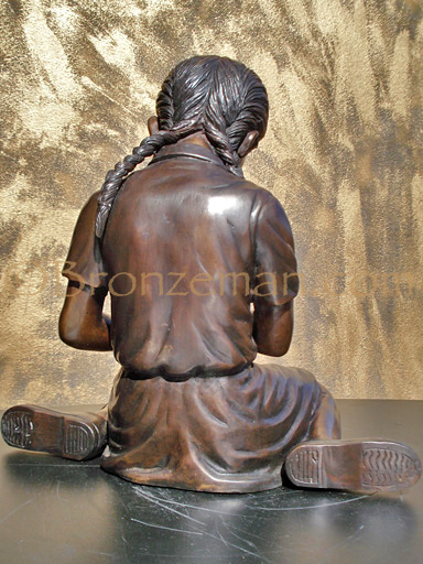 bronze statue of a girl petting a bird