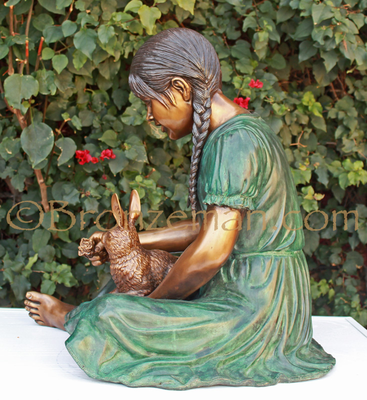 bronze statue of a girl and rabbit
