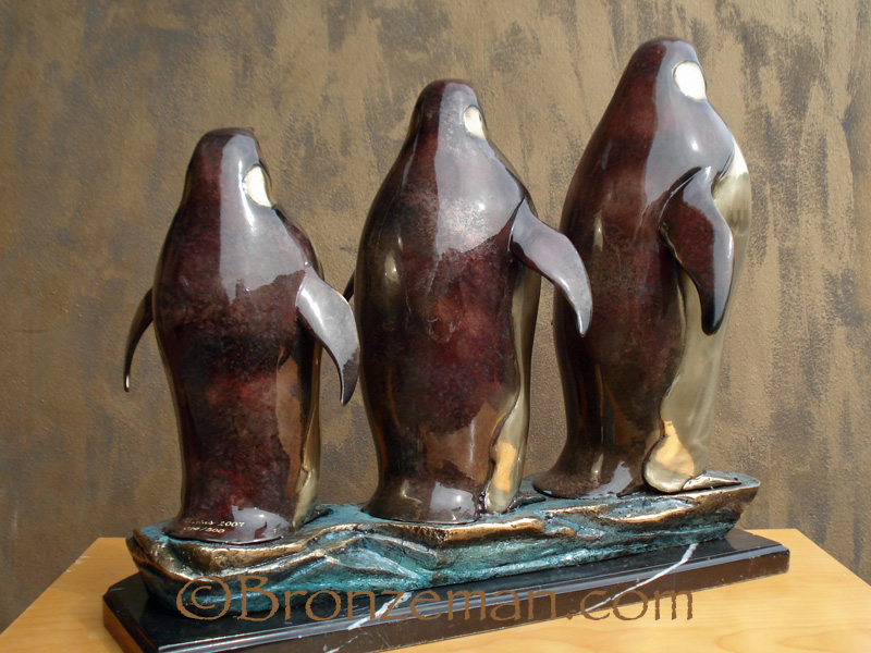 bronze statue of three penguins