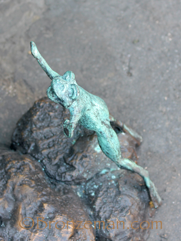 bronze statue of girl with frog