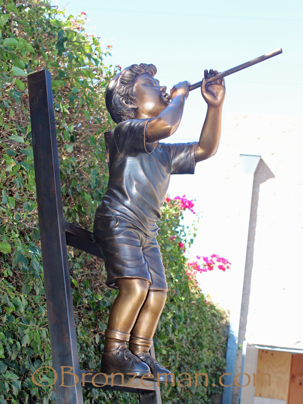 bronze statue of boys on ladder