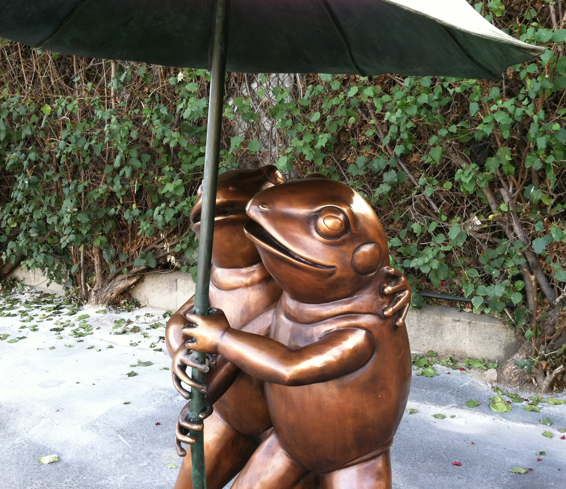 bronze statue of frogs under umbrella
