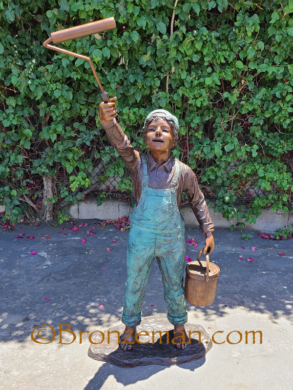 bronze statue of a boy painting
