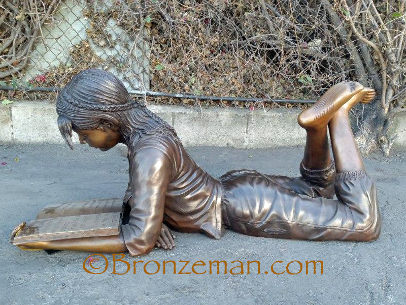 bronze statue of girl reading book