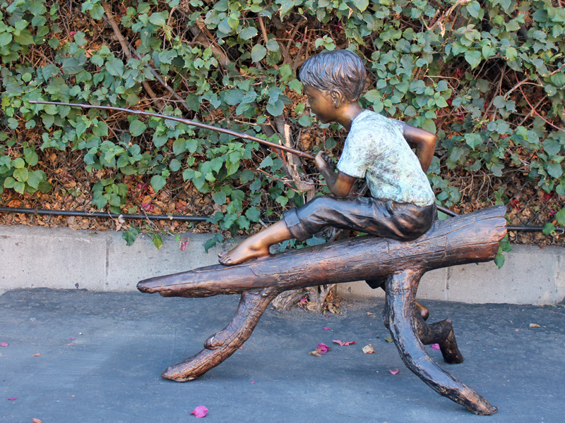 bronze statue of boy fishing