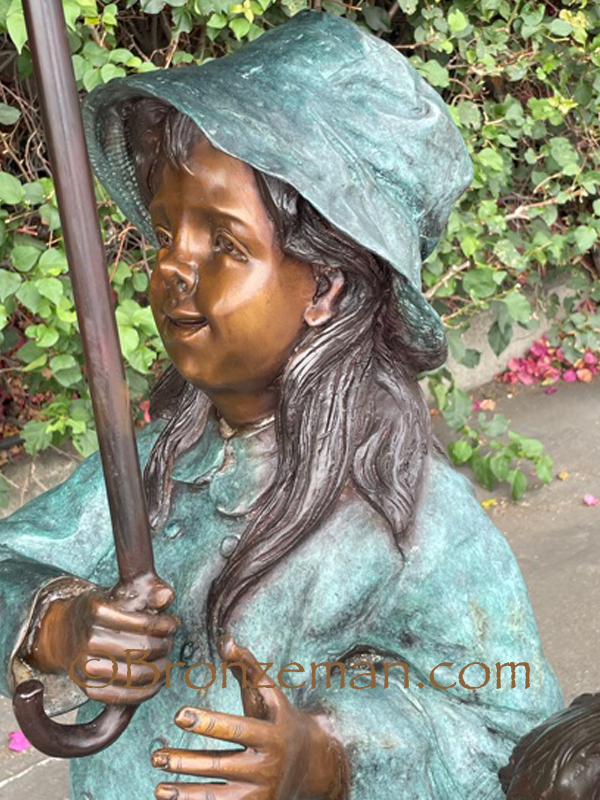 boy and girl with umbrella bronze statue