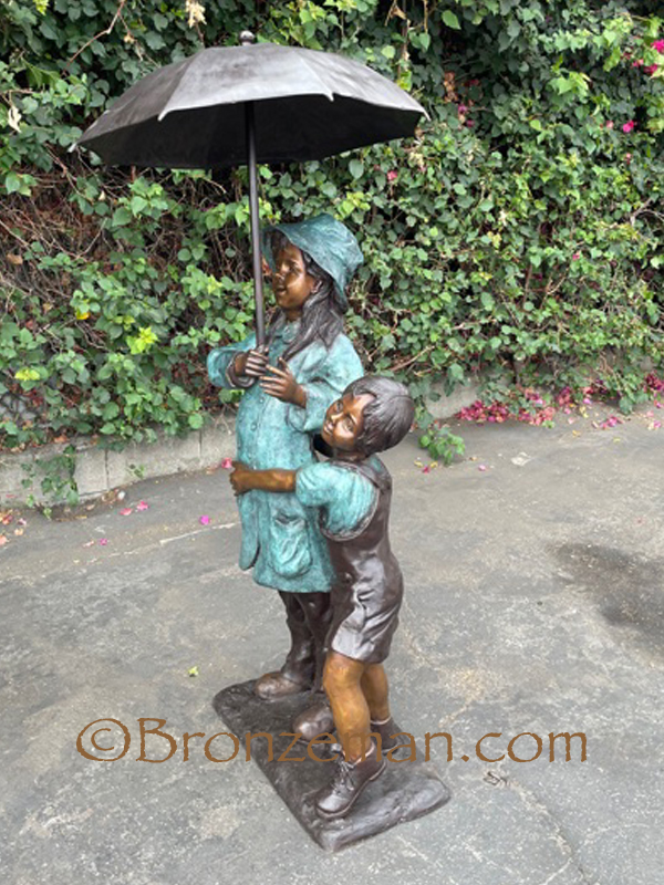 boy and girl with umbrella bronze statue