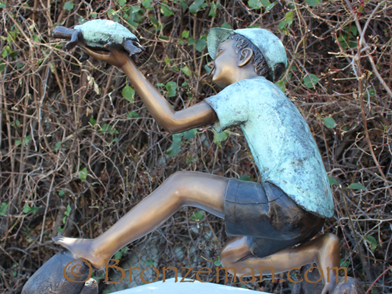 bronze statue of boy with turtle