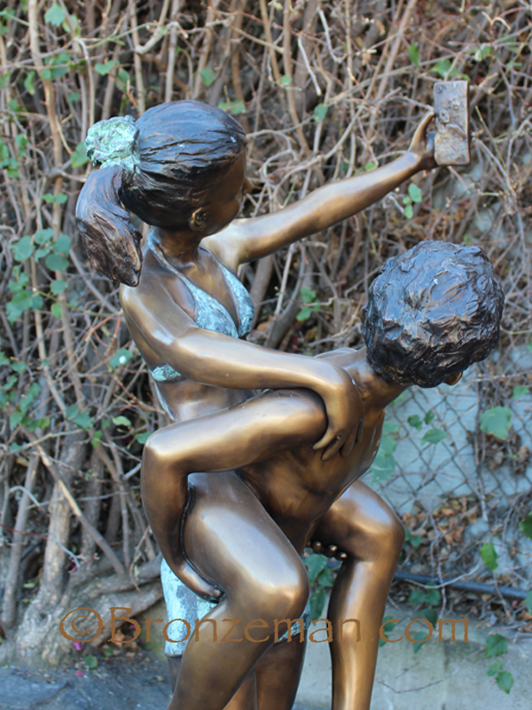 bronze statue of boy and girl taking a selfie