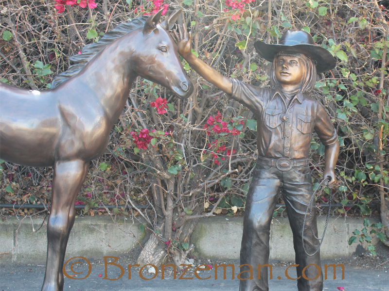 bronze statue of a cowgirl with horse