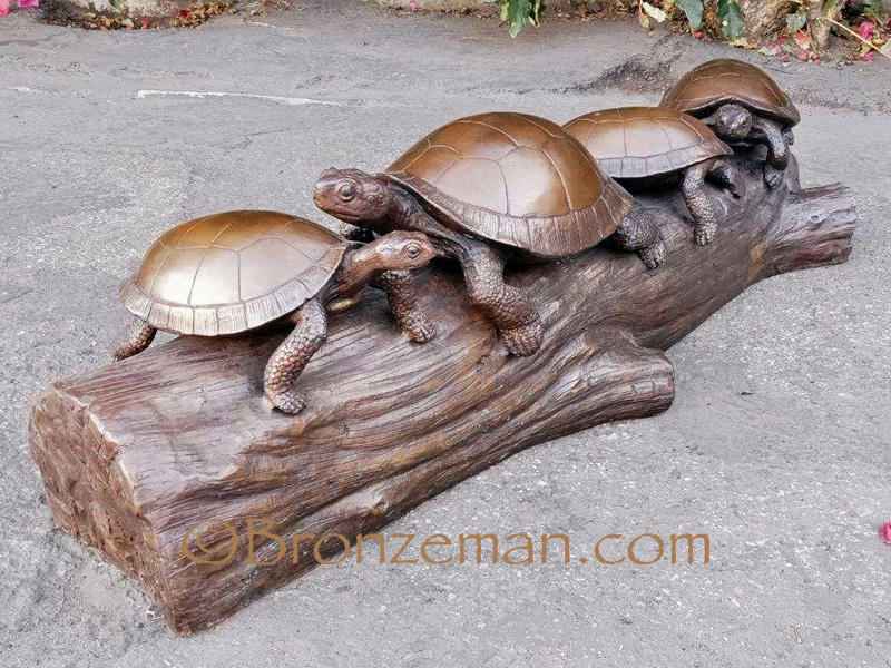 bronze statue of turtles on a log
