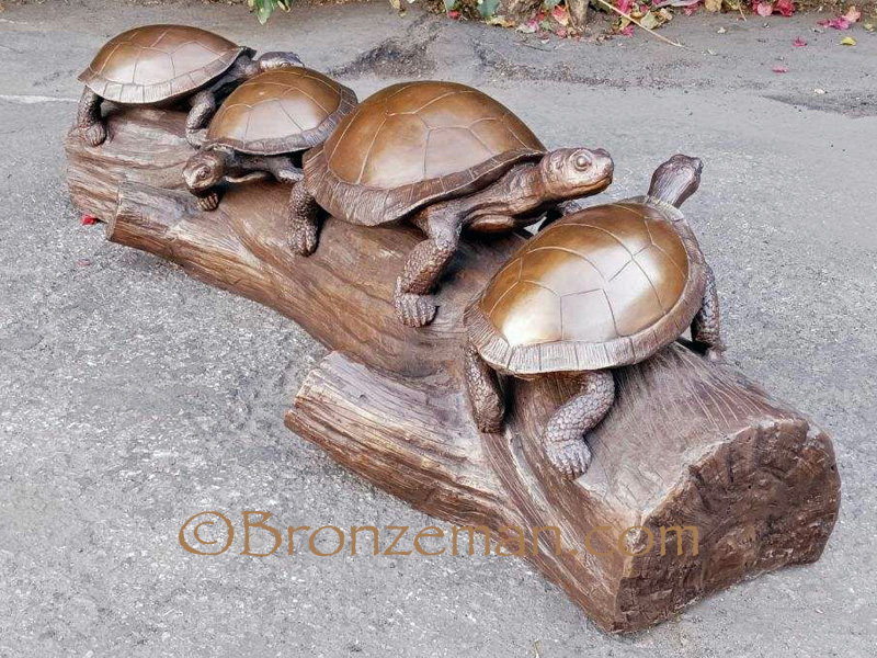 bronze statue of turtles on a log